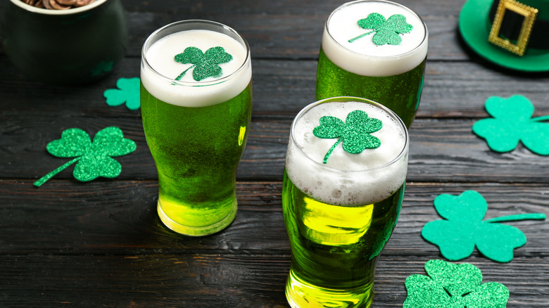 Three glasses of green beer with clovers