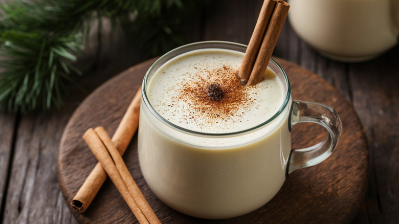 Glass of eggnog with cinnamon stick and nutmeg