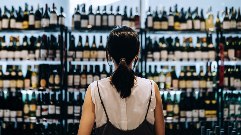 Back of woman in wine aisle of the grocery store