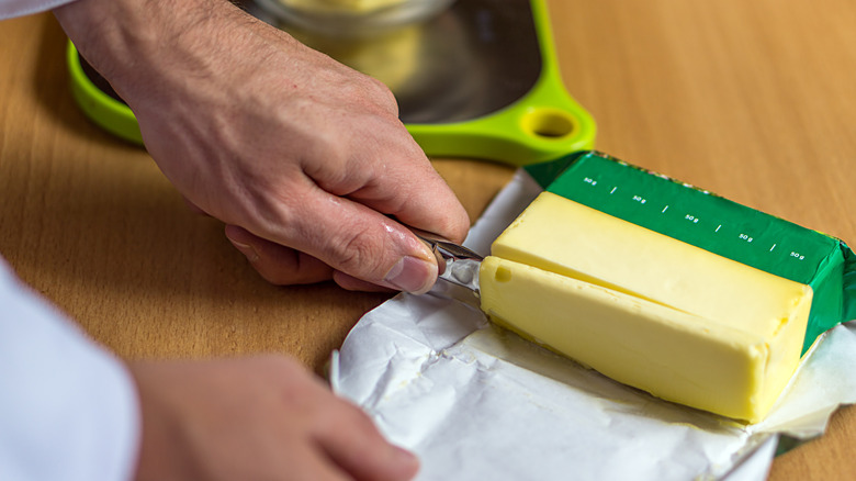 Hand-slicing butter on a tabletop