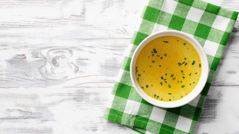 cup of chicken broth or stock on a green and white checkered napkin
