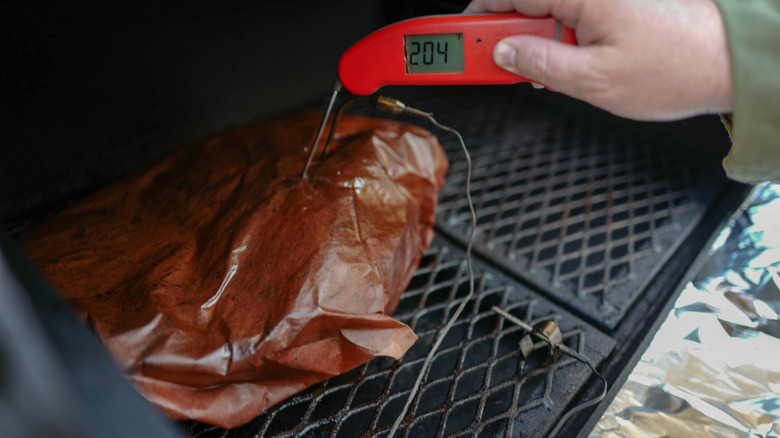 Brisket wrapped in butcher's paper with thermometer