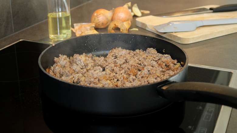 cooked ground beef in a skillet on a stove