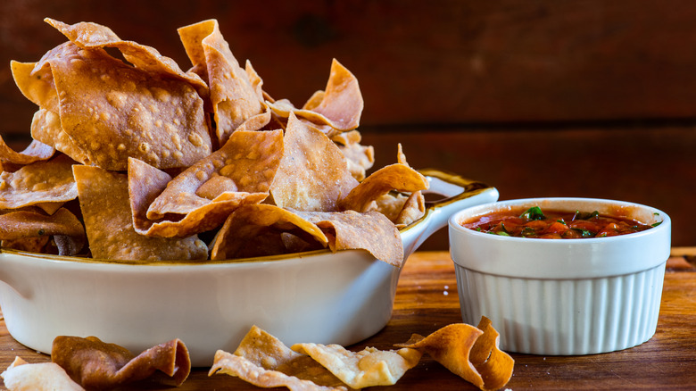 Bowl of tortilla chips next to a small bowl of salsa