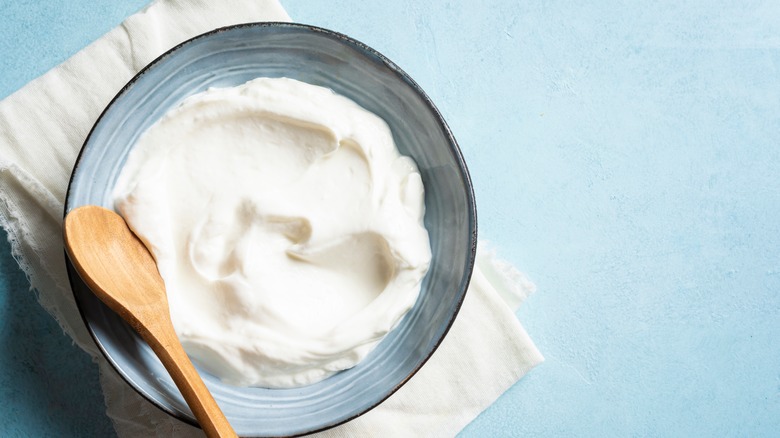 cream cheese in a dish with a wooden spoon