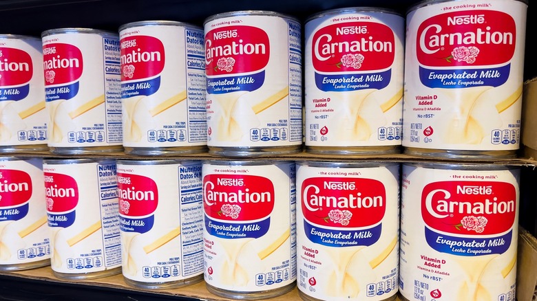 Cans of evaporated milk stacked on shelf