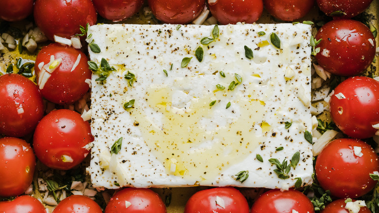 block of feta with olive oil herbs and tomatoes