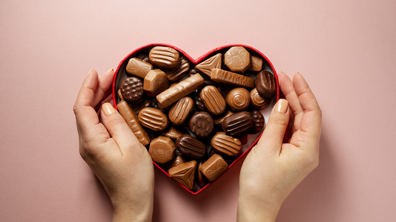 Feminine hands hold a box of chocolates