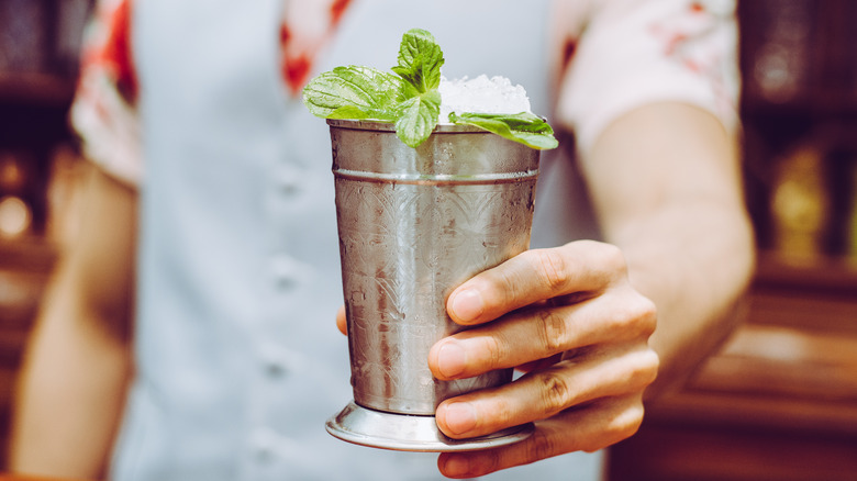 bartender serving a mint julep in a silver cup