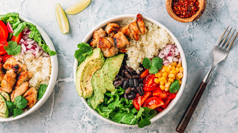 Burrito bowl with chicken, avocado, and other toppings.