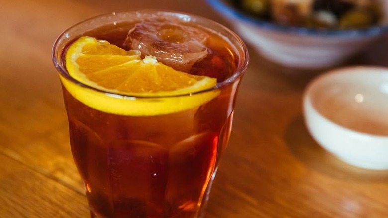 Picon punch with lemon slice on wood counter