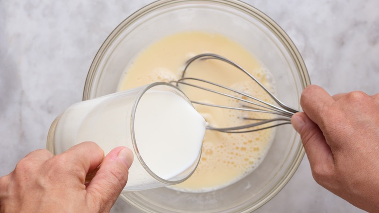 Adding milk to beaten eggs