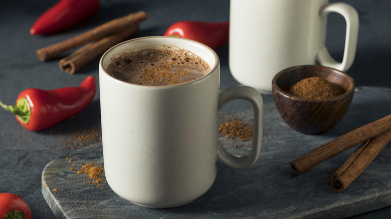Mugs of hot chocolate with peppers and cinnamon