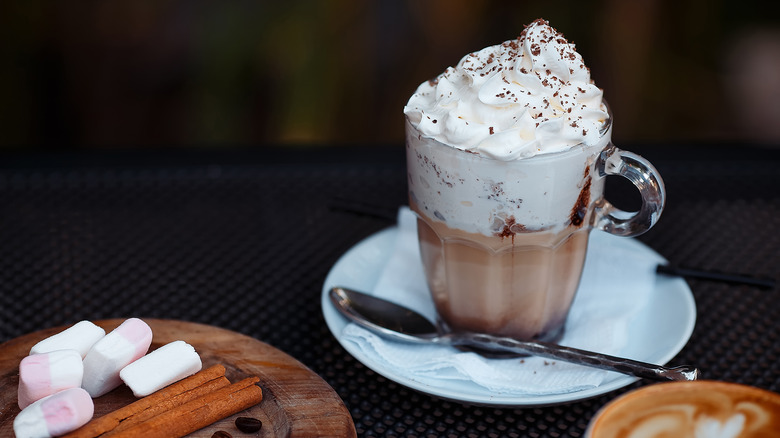 Glass mug of hot chocolate with marshmallows and whipped cream
