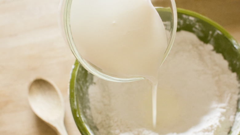 Pouring buttermilk into baking mixture