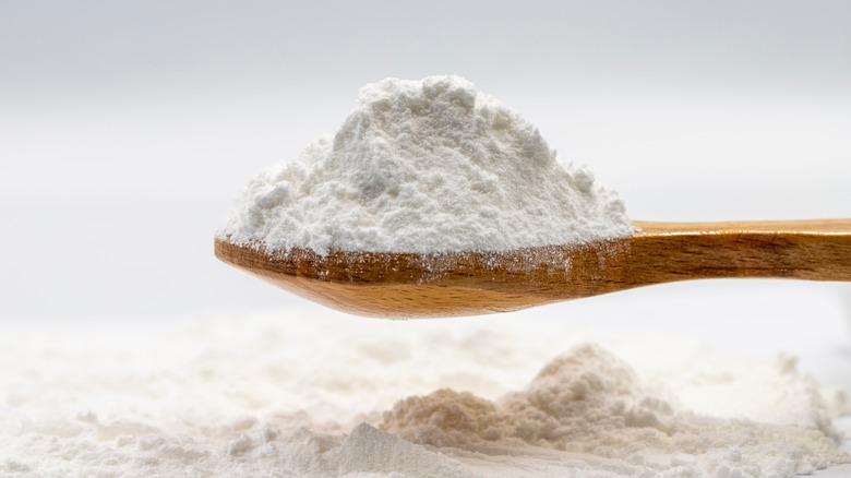 Close up powdered sugar on wood spoon