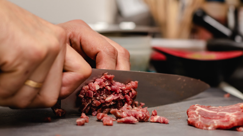 Chef chopping meat for beef tartare