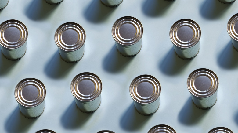 Overhead view of many cans on light blue background