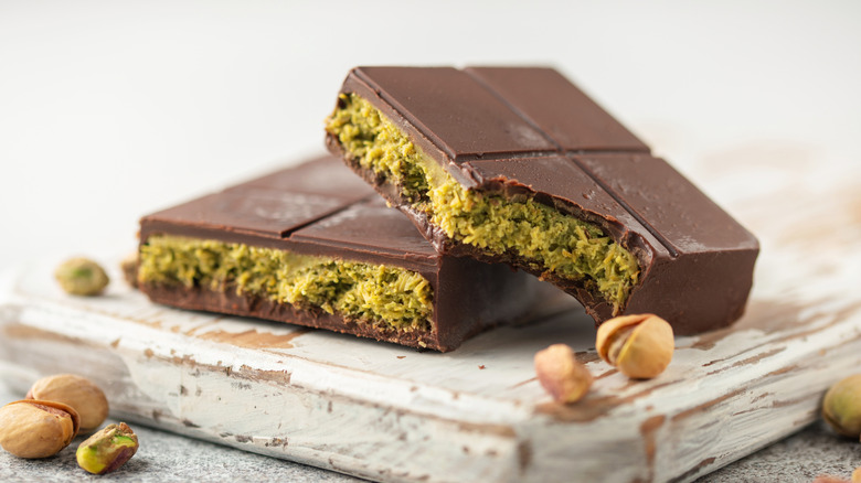 A Dubai chocolate bar on a wooden board with pistachios