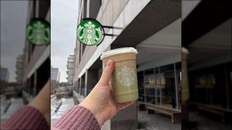 Holding a Starbucks Dubai Chocolate Drink outside the store