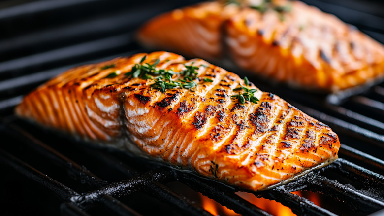 Perfectly charred salmon fillets on a grill.