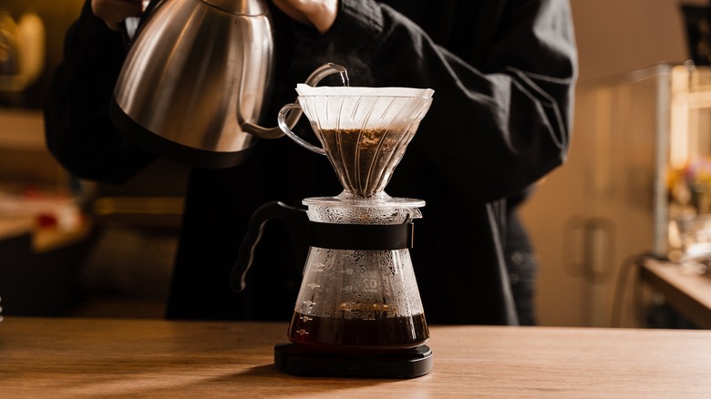 Pouring water over coffee grounds for drip filter brewing.