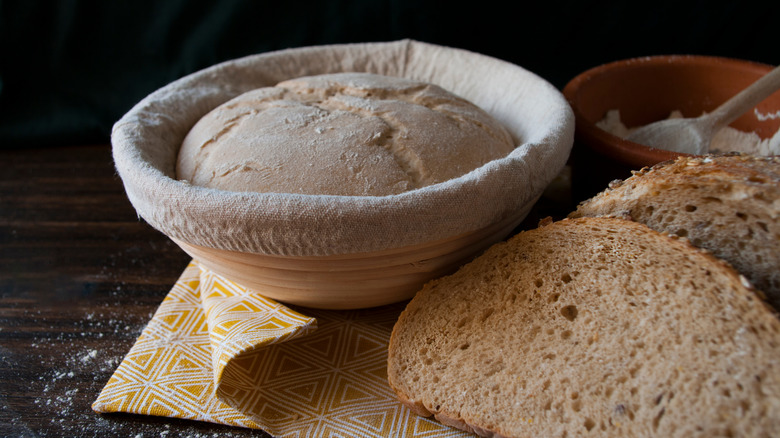 Bread next to dough in proofing basket