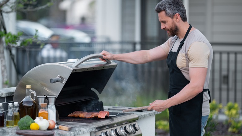 Man cooking fish on a grill