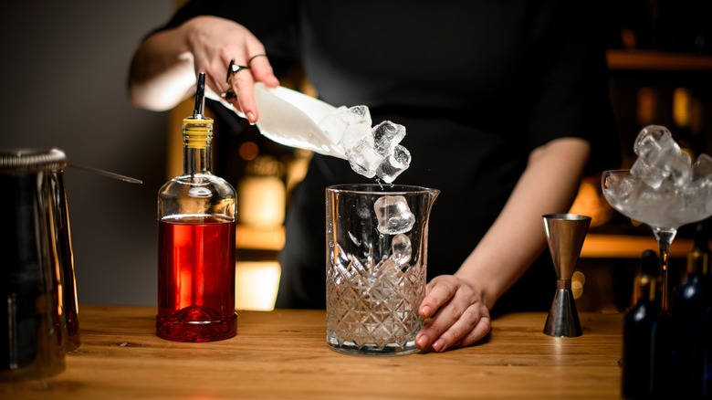 Bartender adding ice for a stirred cocktail