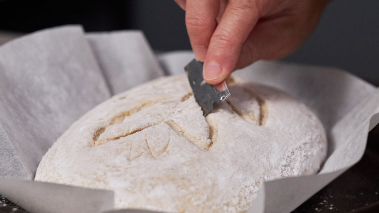 Scoring dough with a razor.