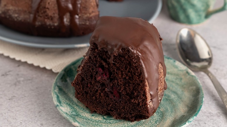 chocolate bundt cake with a slice on a plate with spoon