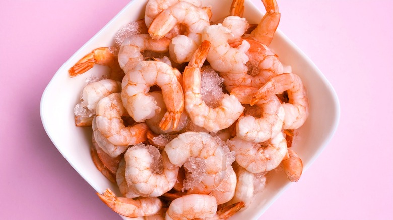 Fresh pink shrimp on ice in a bowl