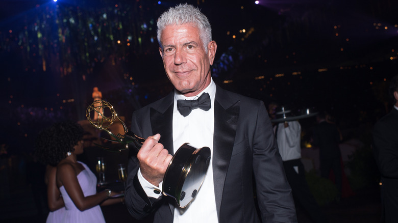 Anthony Bourdain holding an Emmy