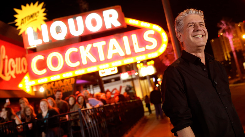 Anthony Bourdain standing in front of a bar