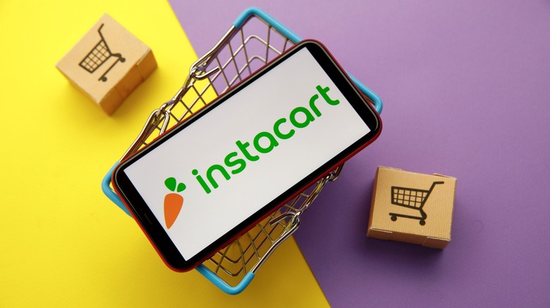 Instacart display on phone placed in mini shopping cart