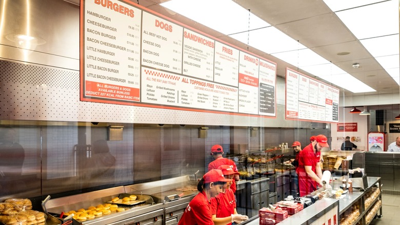 Five Guys menu with employees making food behind counter