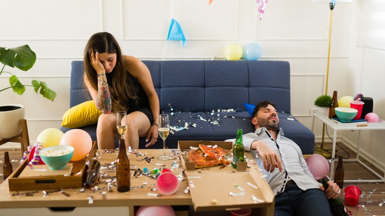 Man with hangover holding empty wine glass