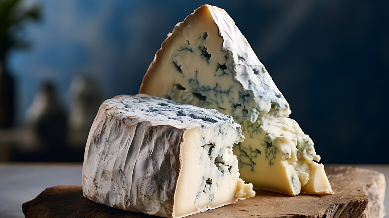 Slices of blue cheese on a wooden board, blue mold