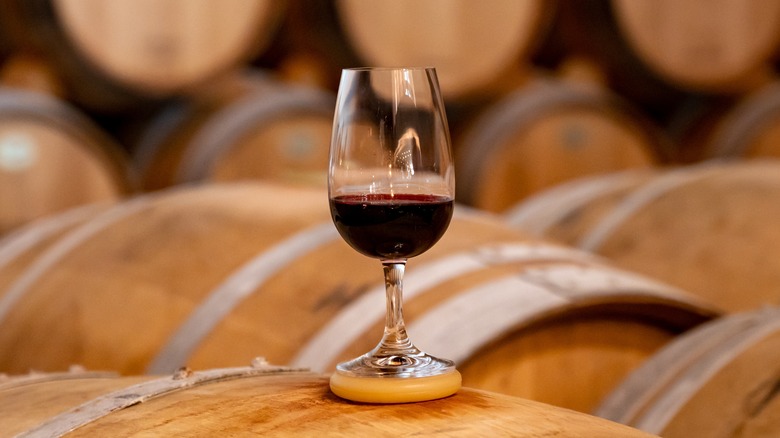 Wine glass on top of wine barrels