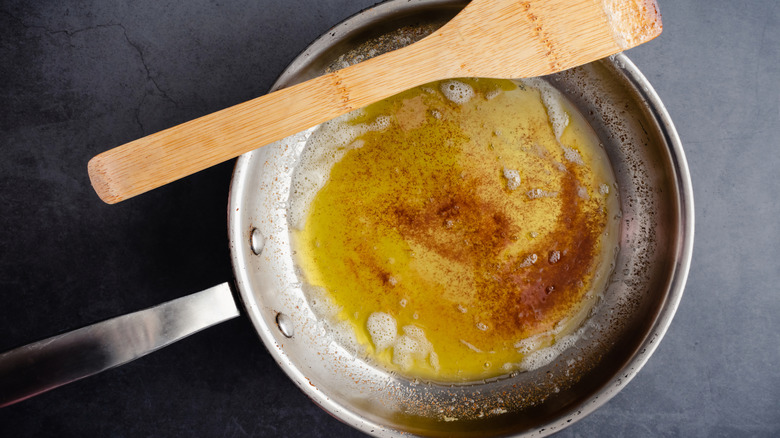 Browned butter in a pan with a spatula resting on the edge.