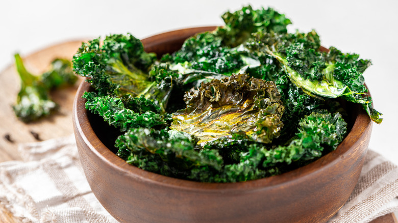 Homemade kale chips in wooden bowl