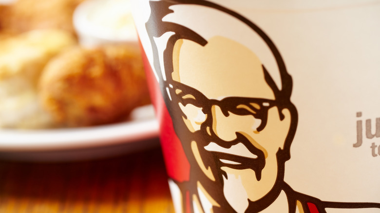 A bucket of KFC chicken sits on a table