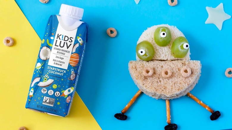 KidsLuv beverages next to spaceship alien made of bread, grapes, and pretzels