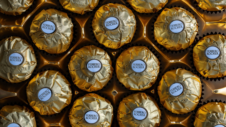 Close up of the inside of a box of Ferrero Rocher candies wrapped in gold foil