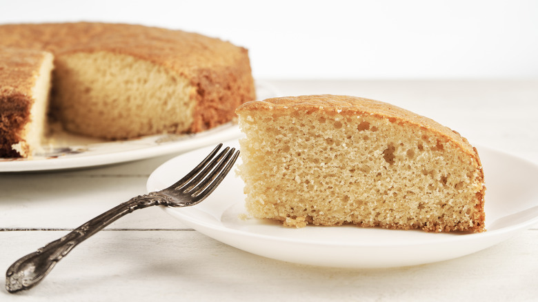 Slice of yellow cake without frosting on white plate.