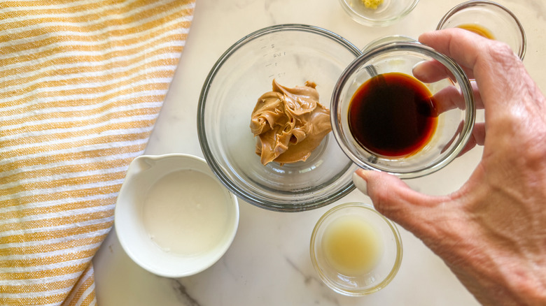 hand adding soy sauce