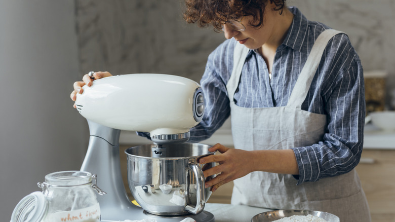 A person making dough in a stand mixer