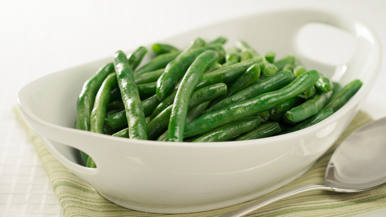 A white dish of green beans