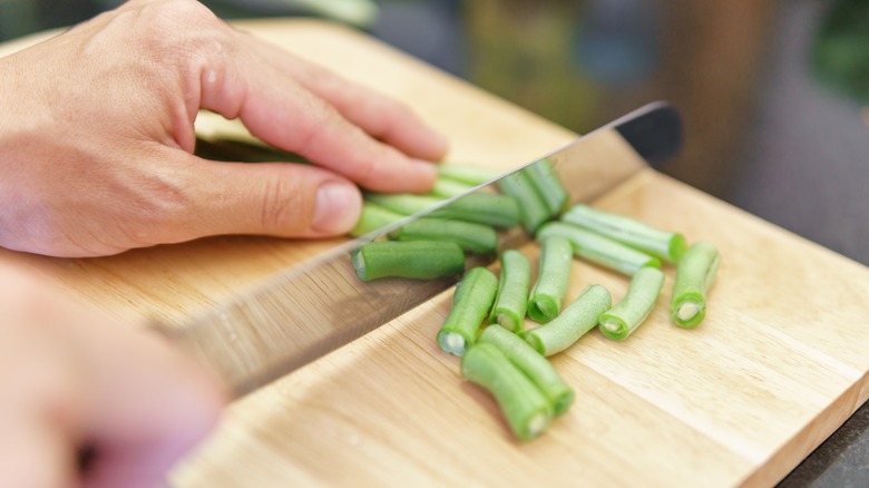 Cook chopping up green beans 