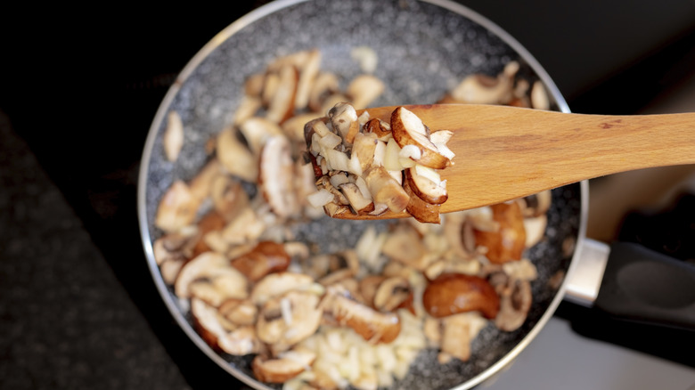 Mushrooms on a spatula over a pan